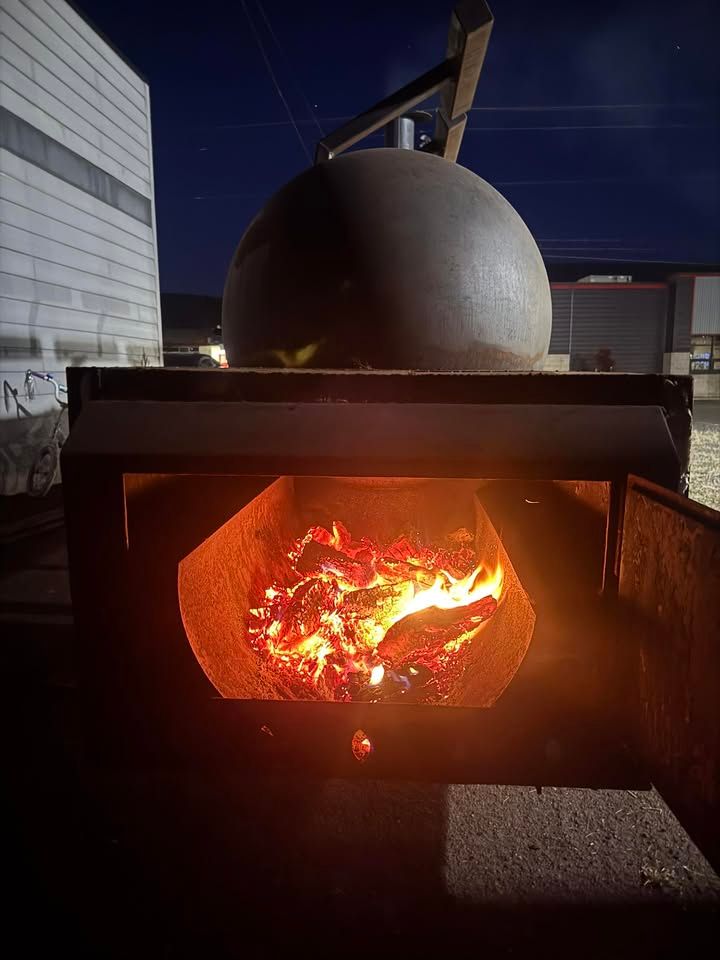 The smoker’s firebox glowing with embers at night